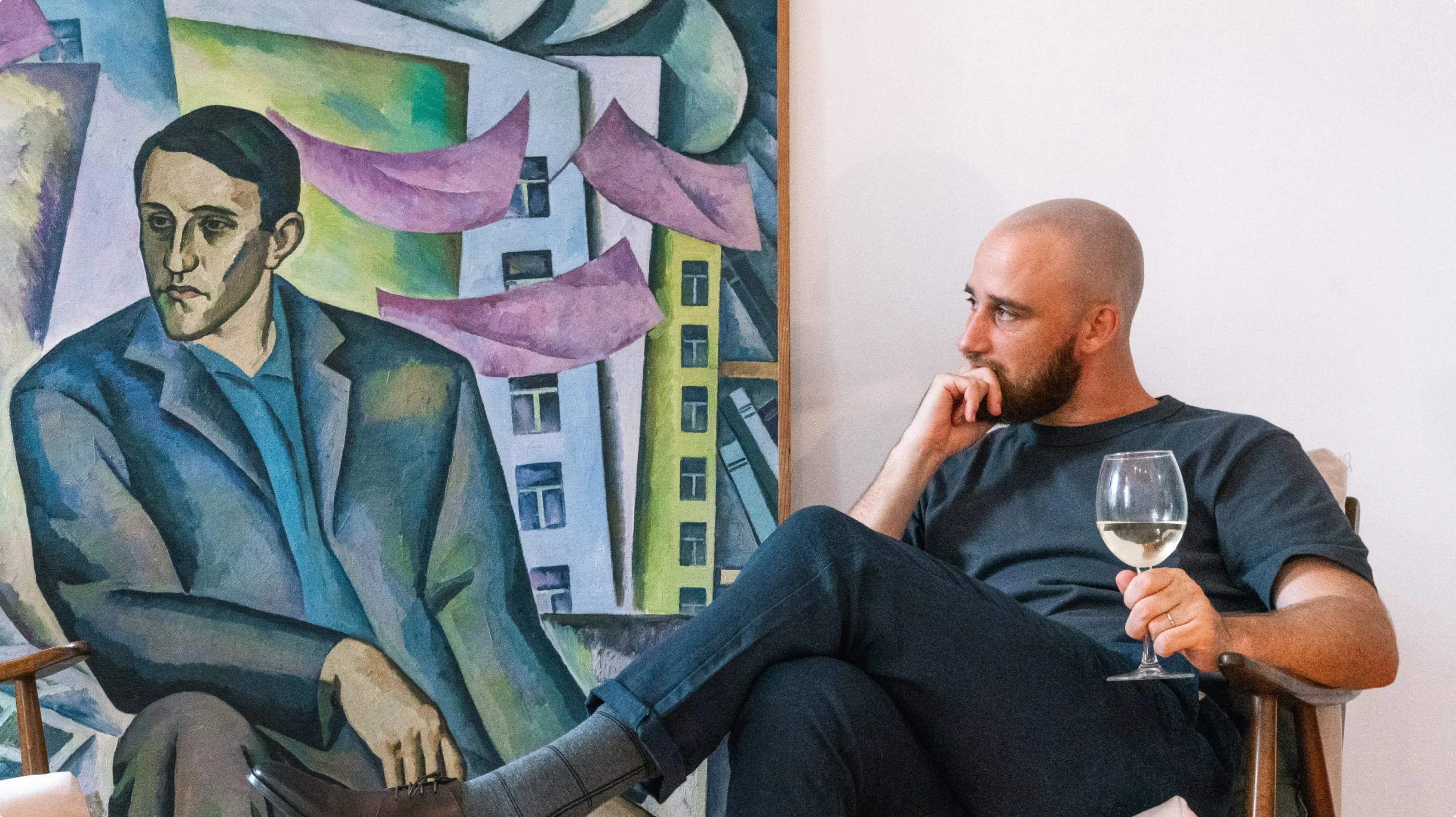 Collector viewing artwork with a glass of wine