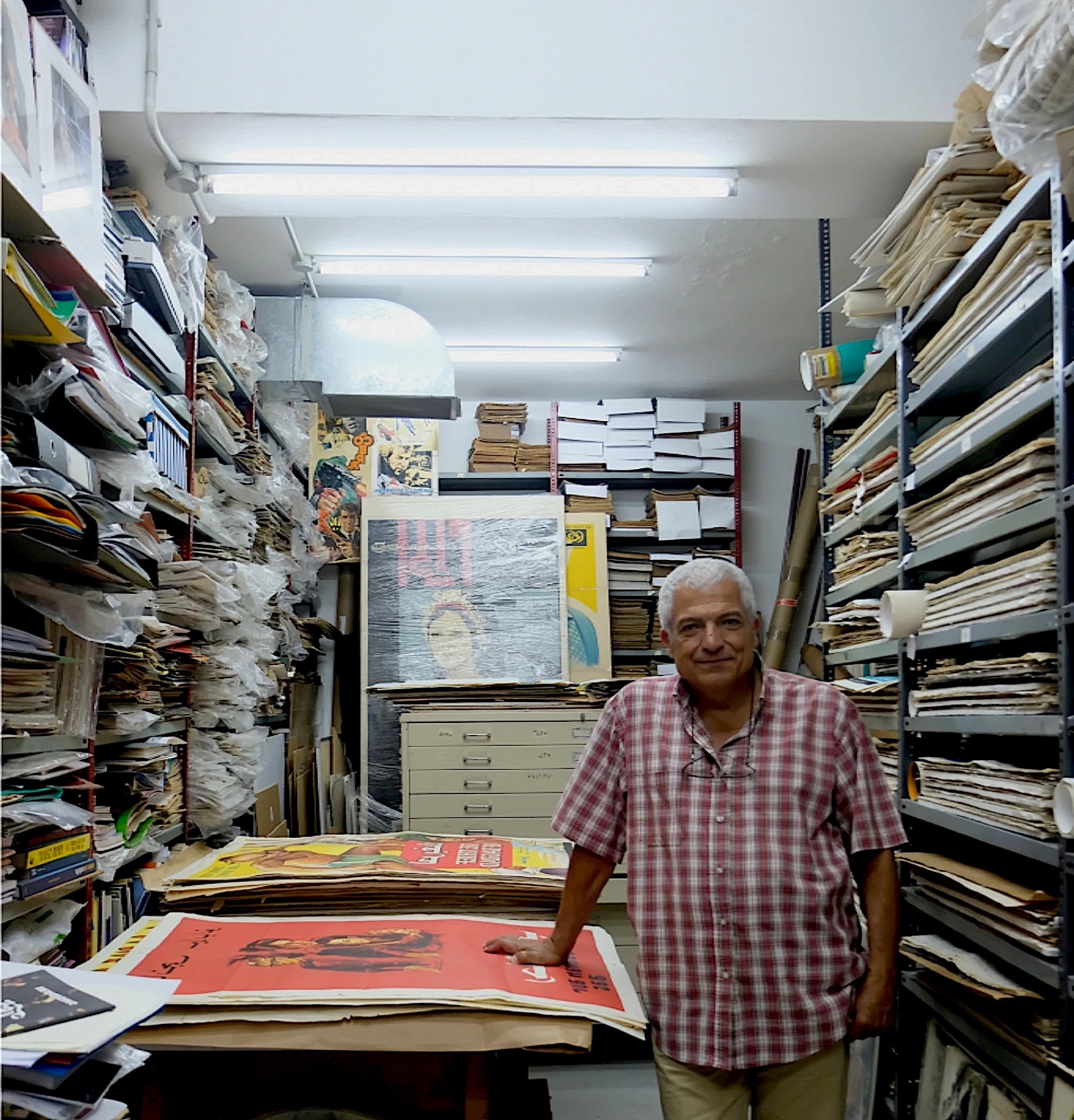 Dealer standing in his stockroom of prints