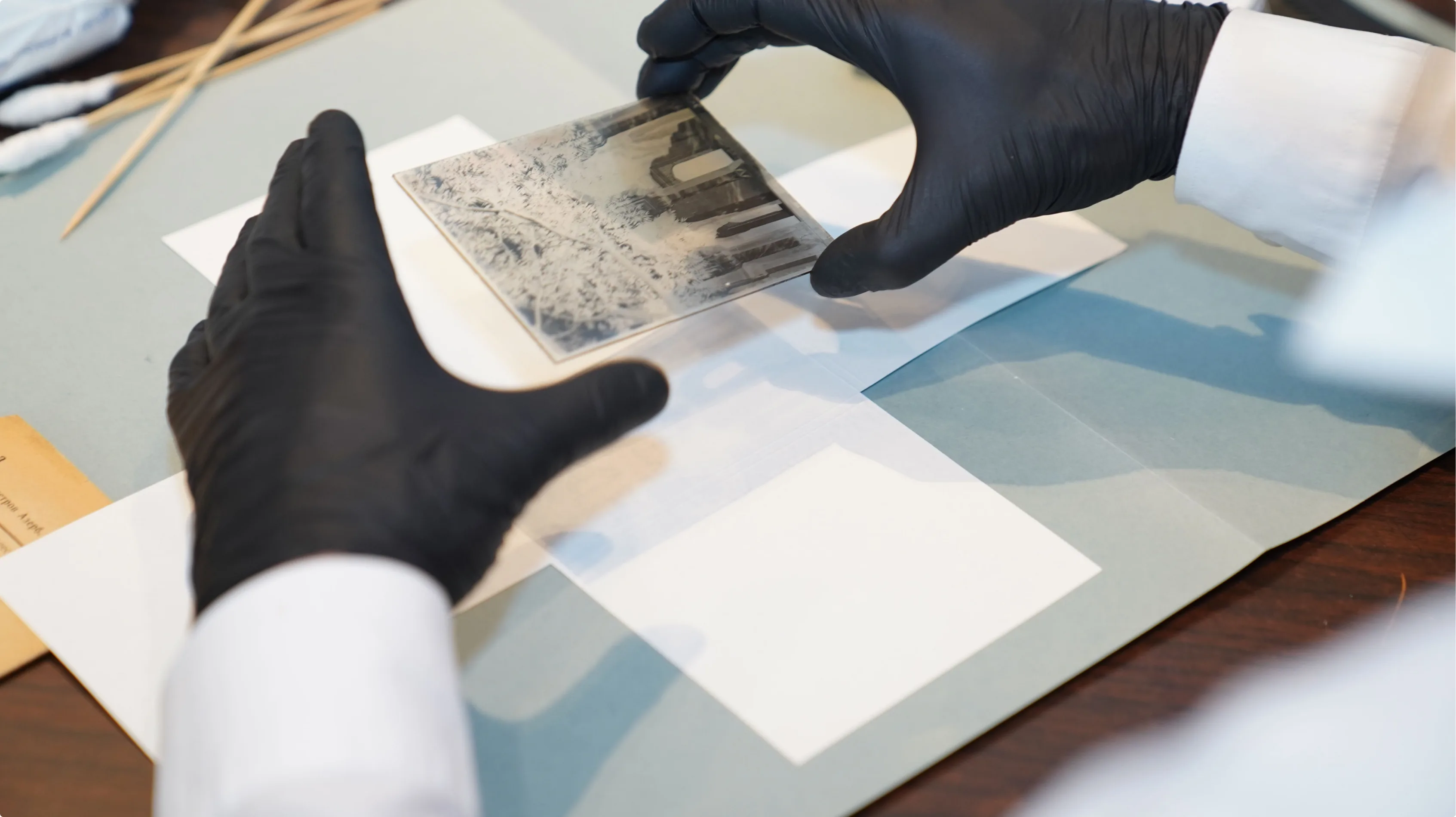 Gloved hands handling archival photographic materials