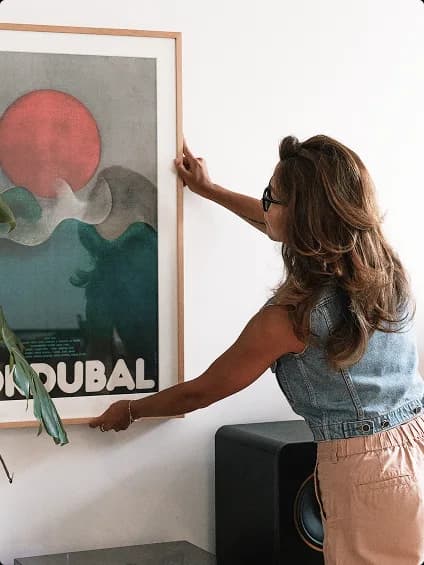 Collector reviewing artwork in a home gallery