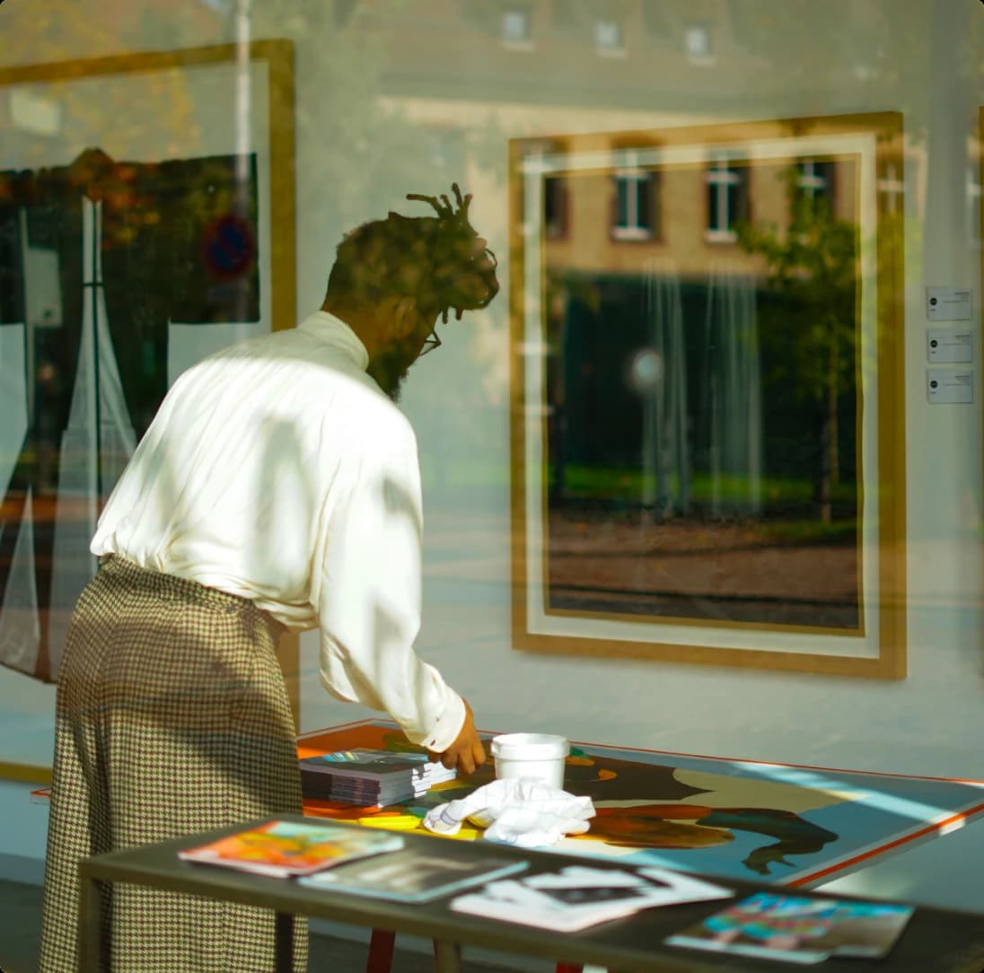 Dealer arranging prints on a table in a gallery